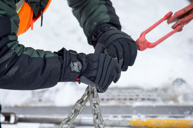 Image of construction worker attaching a chain while wearing Mechanix Wear cold work gloves.