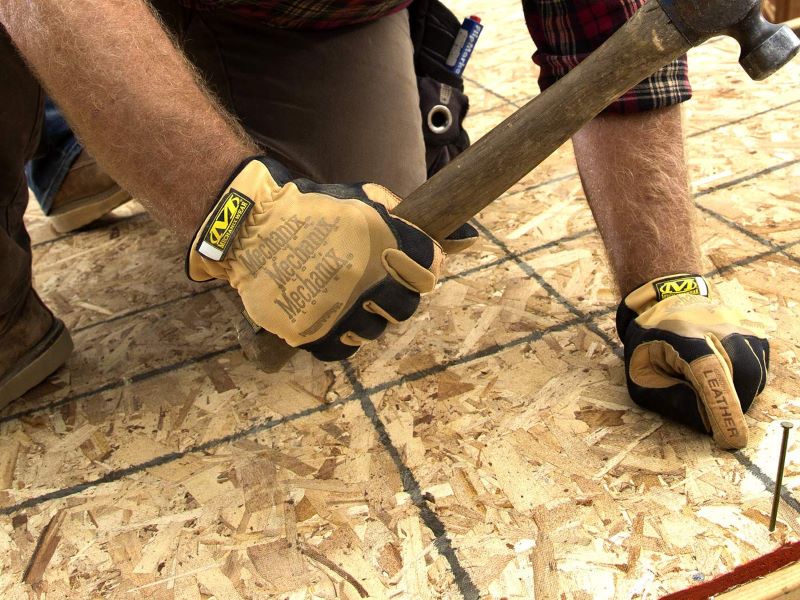 Image of a carpenter working while wearing Leather FastFit gloves from Mechanix Wear.